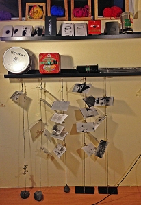 A variety of pinhole cameras with representative pictures hung below.